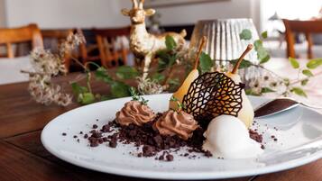 A dessert plate with chocolate mousse and a chocolate lattice on a white plate.