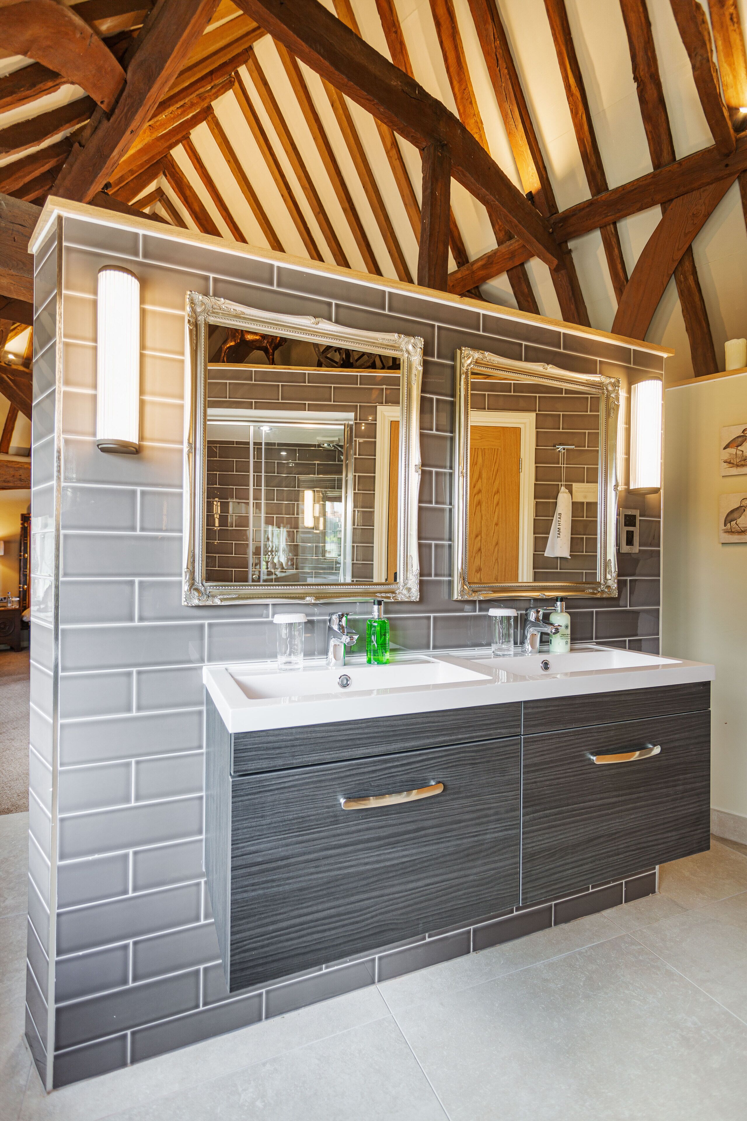 Een badkamer met een groot wastafelmeubel, twee wasbakken en een spiegel.