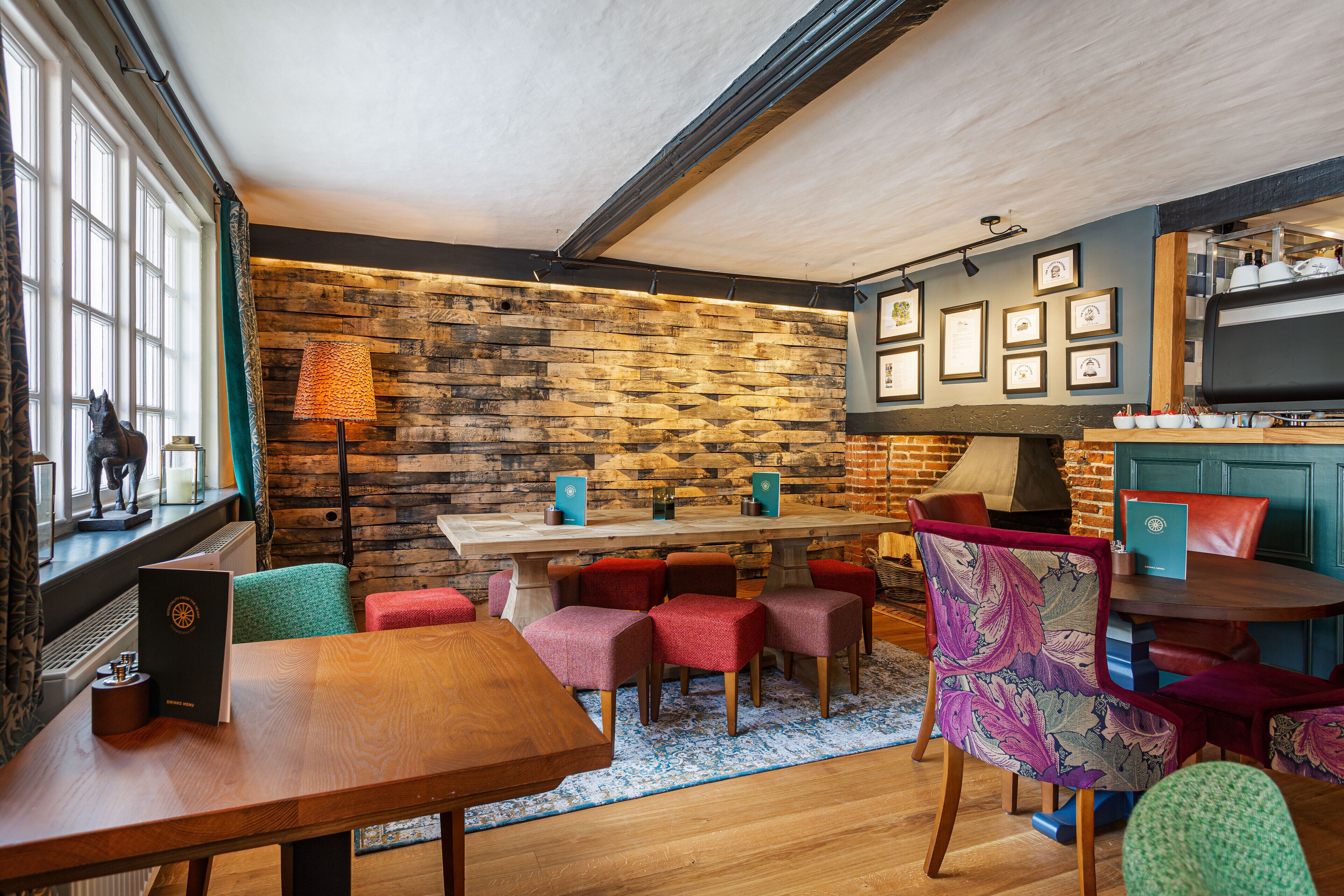 Une pièce chaleureuse avec un mur en bois, une table à manger et des chaises rouges.