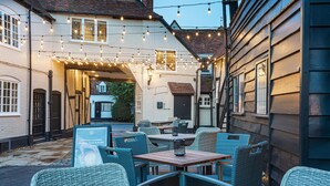 An outdoor seating area with wicker furniture and string lights.