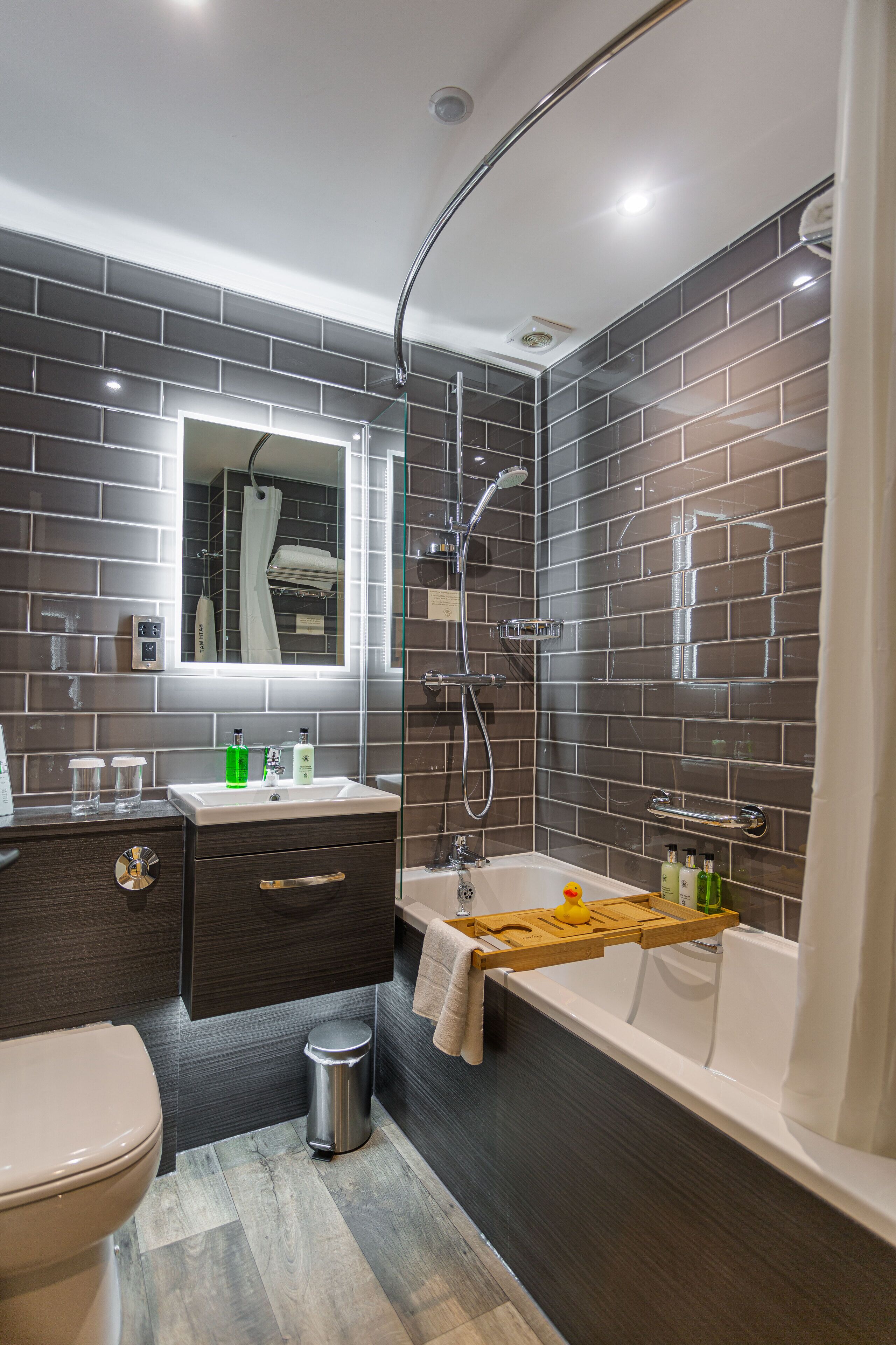 A modern bathroom with a shower, toilet, and vanity.