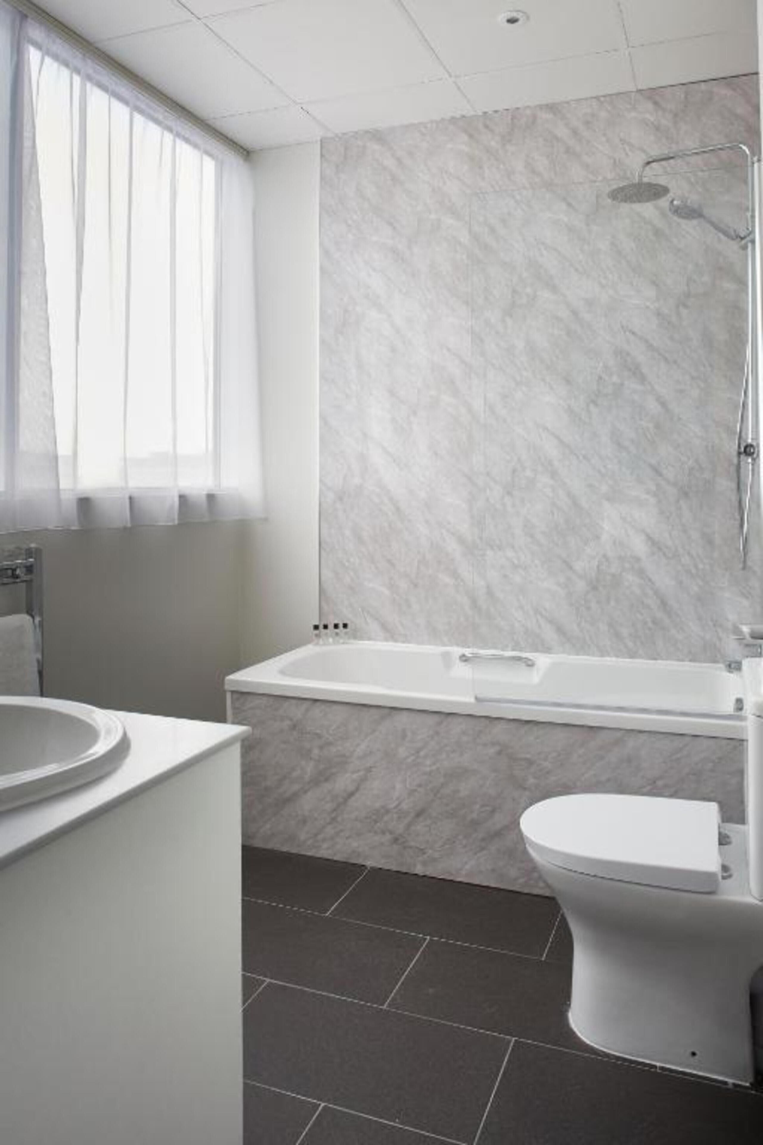 Une salle de bain avec une baignoire, des toilettes et un lavabo.