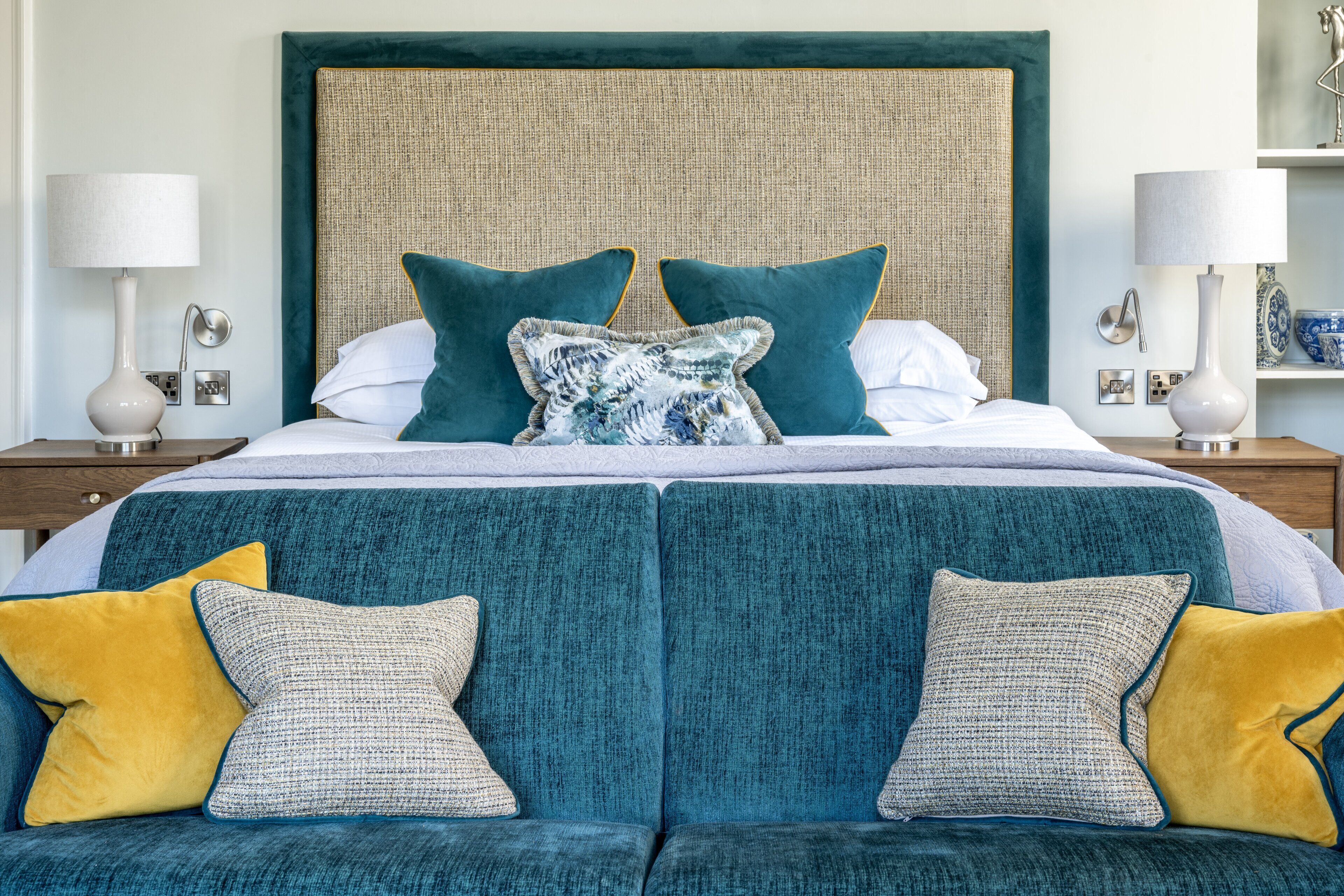 Une chambre à coucher bien aménagée, avec un grand lit, deux tables de chevet et un canapé.