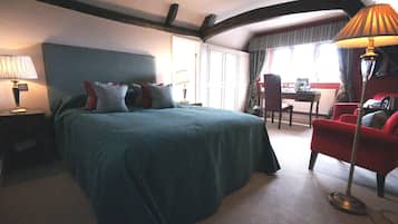 Una habitación de hotel con una cama grande, un escritorio, una silla y una lámpara.