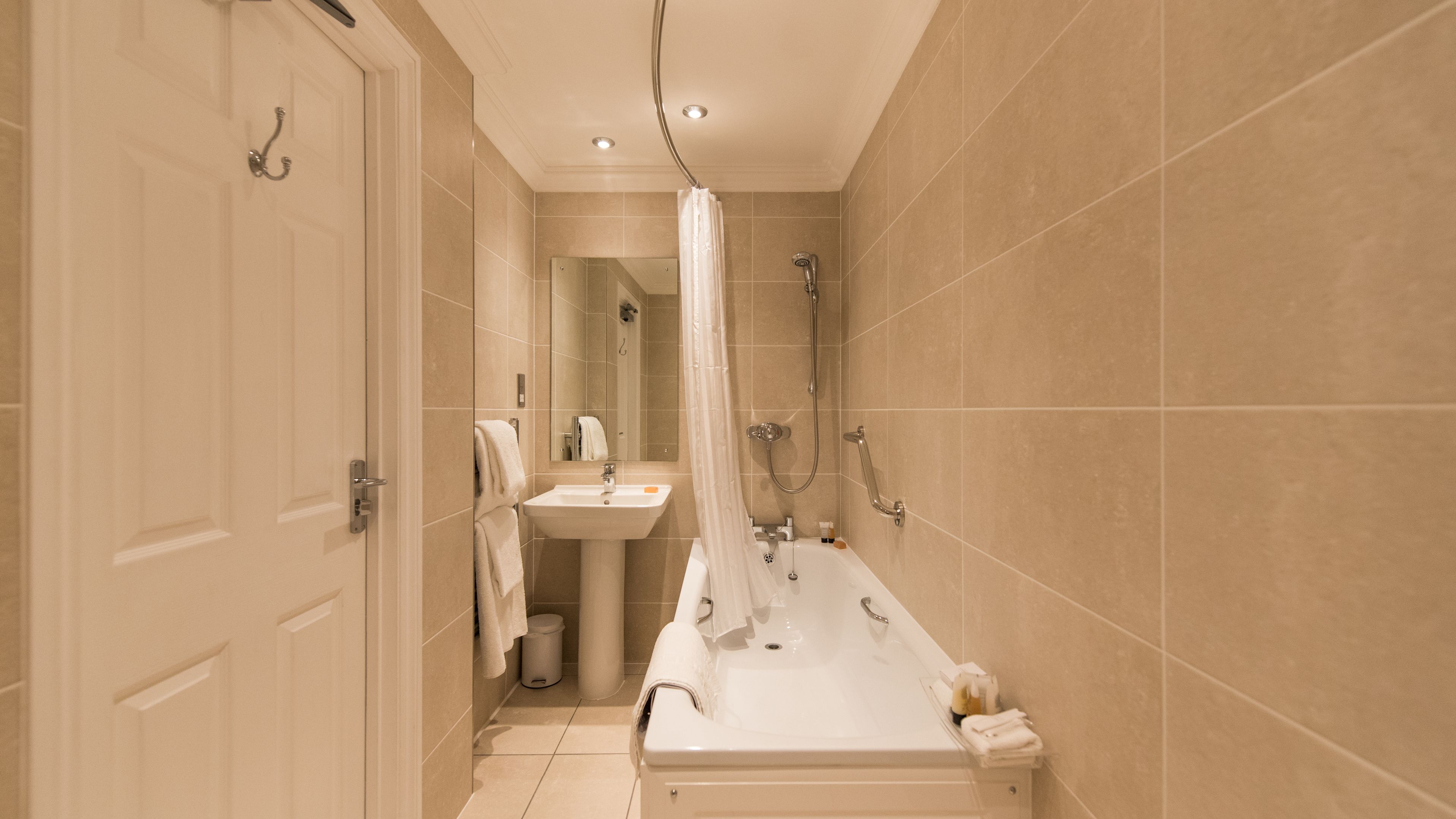 A modern bathroom with a bathtub, a sink, and a shower.
