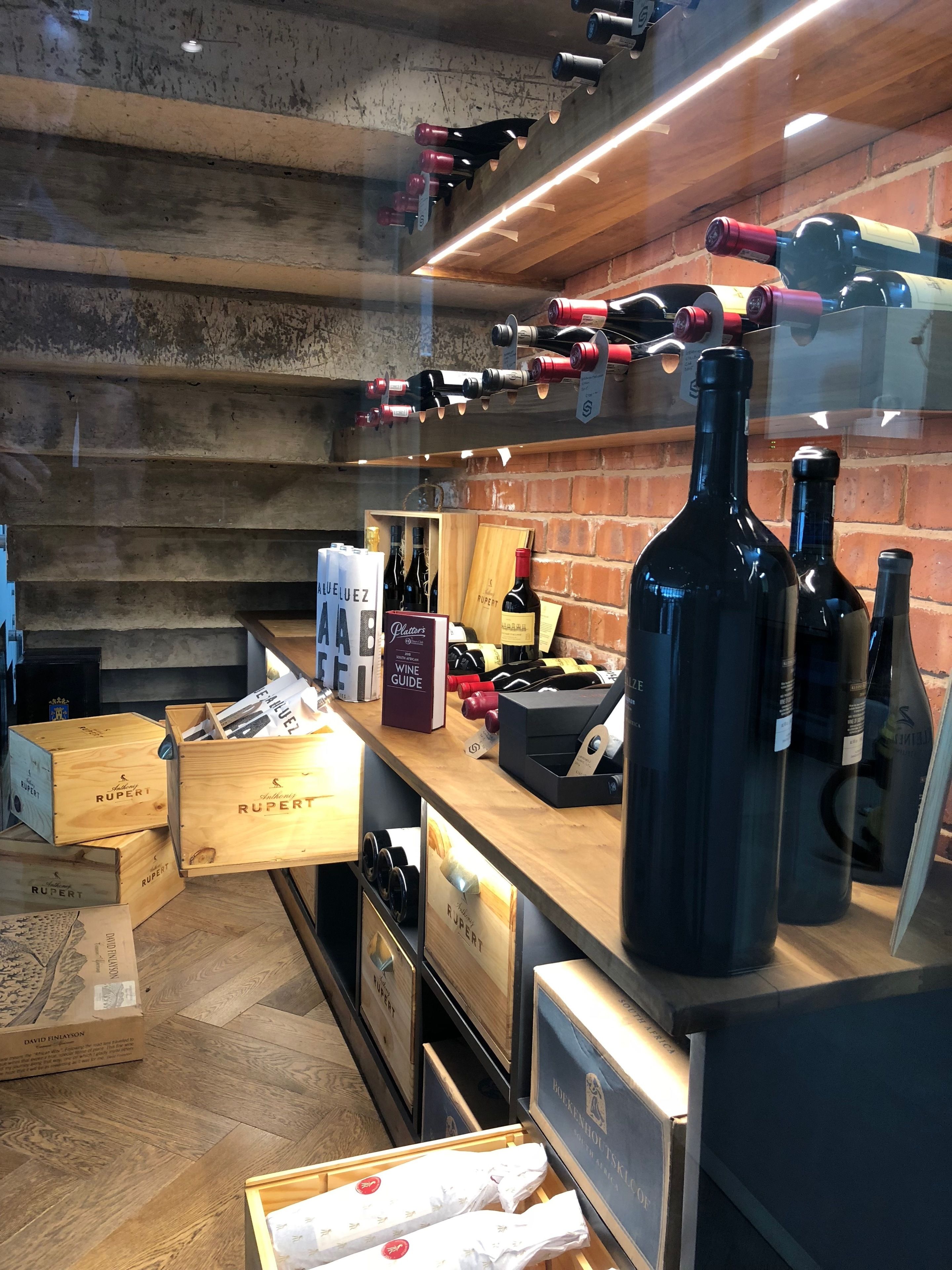 Una bodega con cajas de madera, botellas de vino y una guía del vino sobre la encimera.