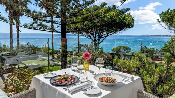 An outdoor dining area with a table set for two, overlooking a coastal view. -  Boutique Hotel Vivenda Miranda (Lagos)