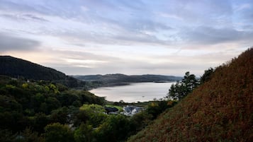 Una vista panorámica de un lago rodeado de colinas y un bosque denso.