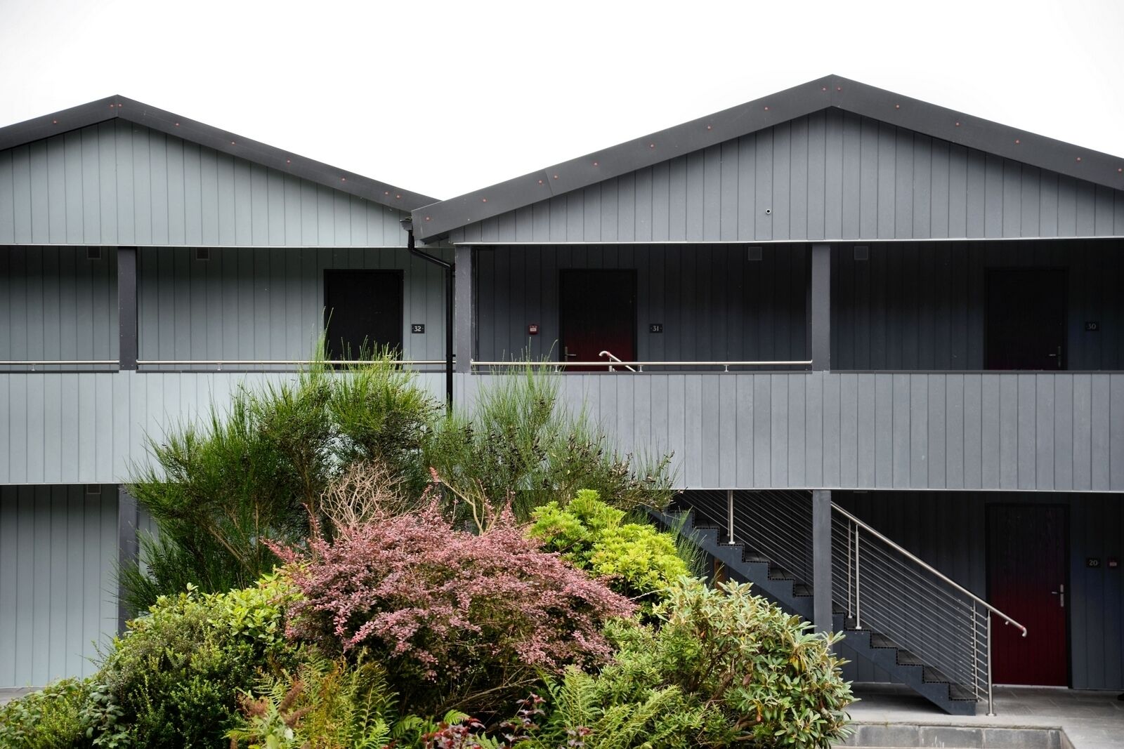 A two-story building with a modern design, featuring a staircase leading to the upper floor.