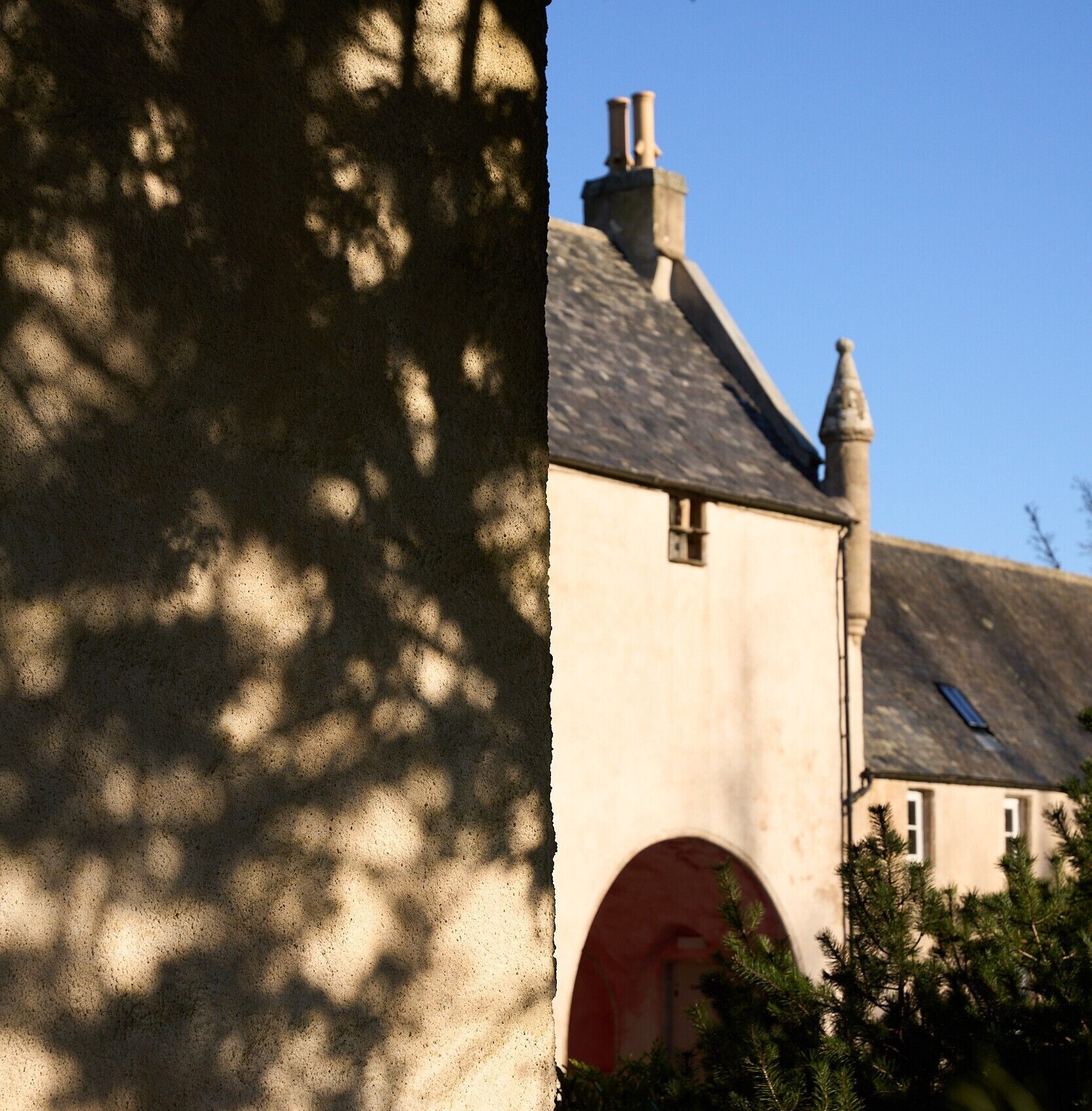 Un bâtiment doté d’une façade en pierre, d’un toit à deux versants et d’une cheminée.