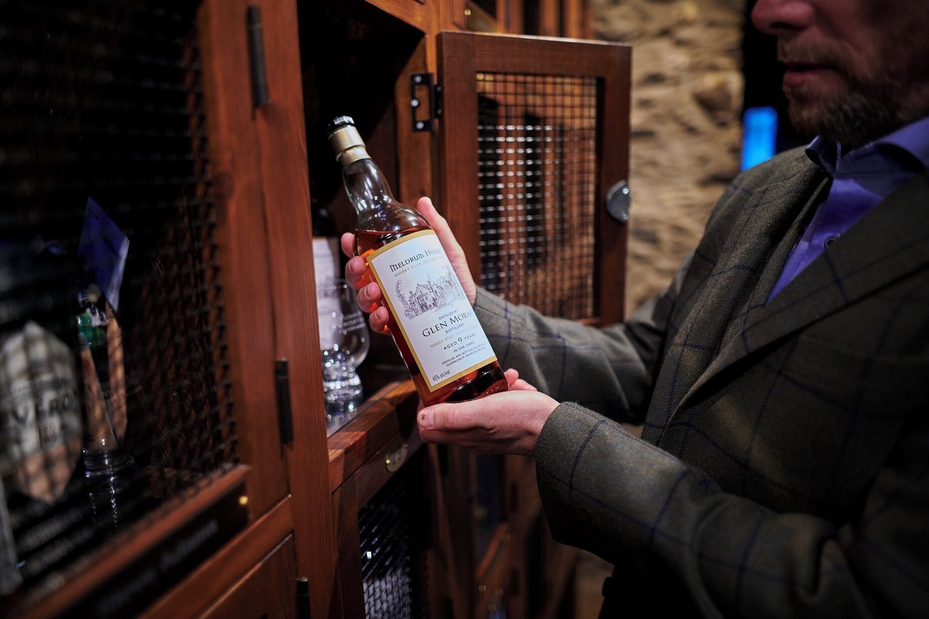 Una persona sostiene una botella de whisky Glenmorangie.