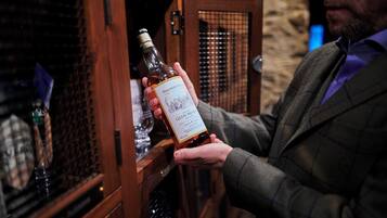 Una persona sostiene una botella de whisky Glenmorangie.