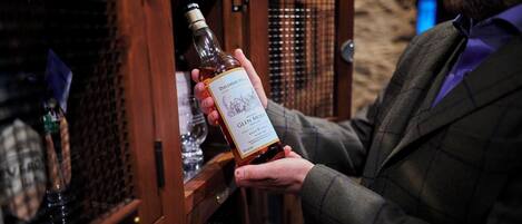 A person holding a bottle of Glenmorangie whisky.