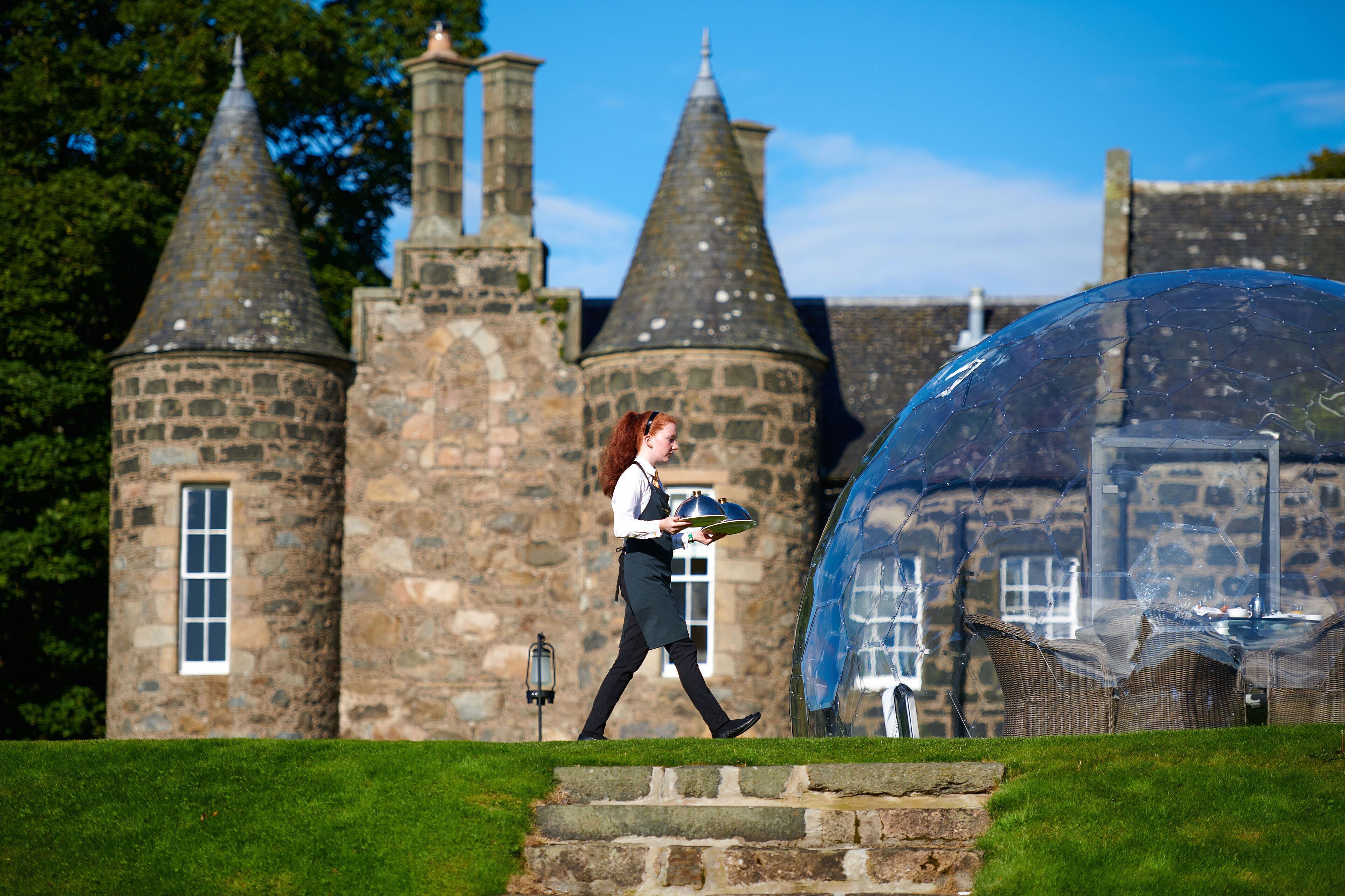 A historic stone building with multiple towers and a clear sky.