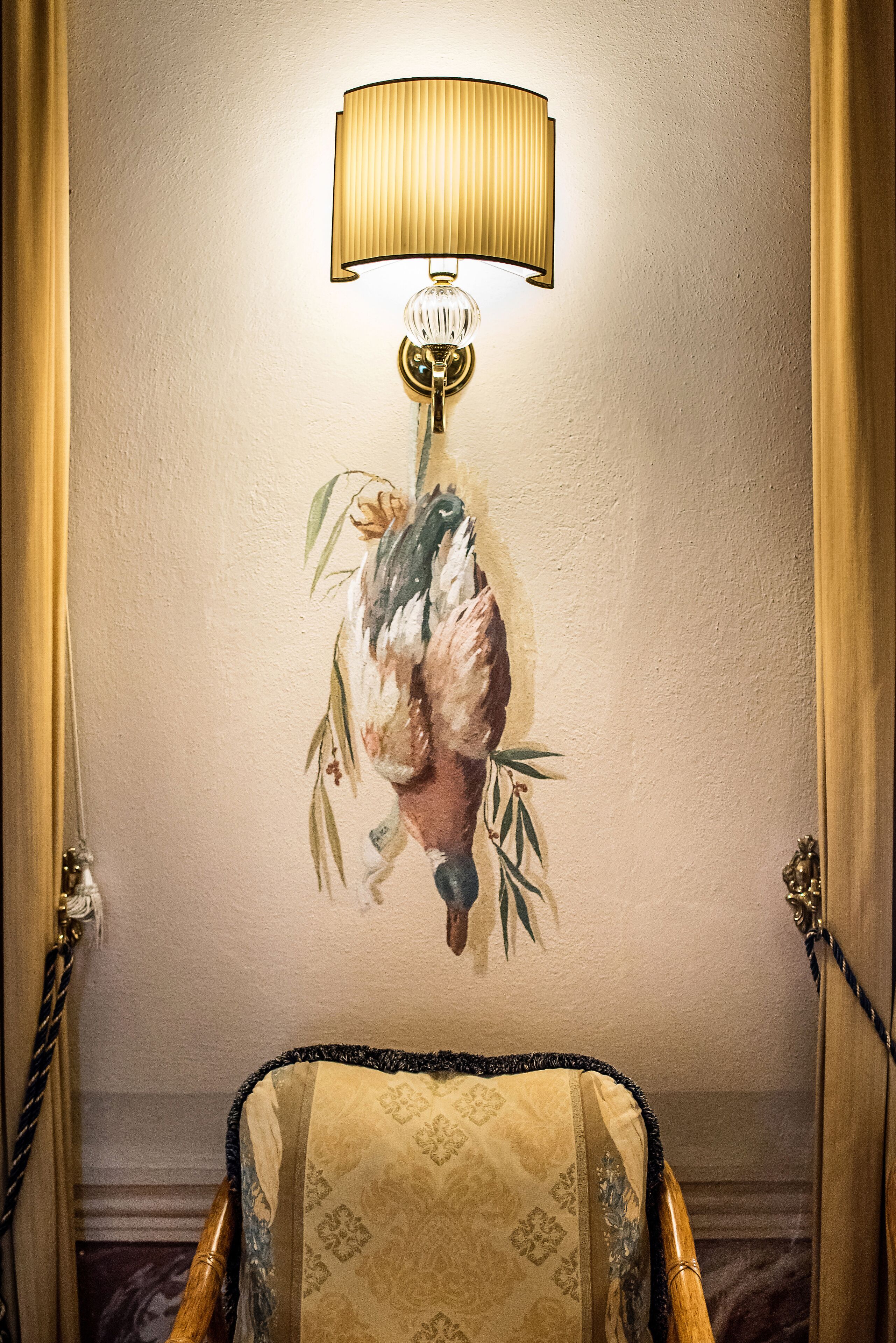 Une lampe murale ornée d’un motif floral décoratif, une chaise à motifs et un mur à texture.