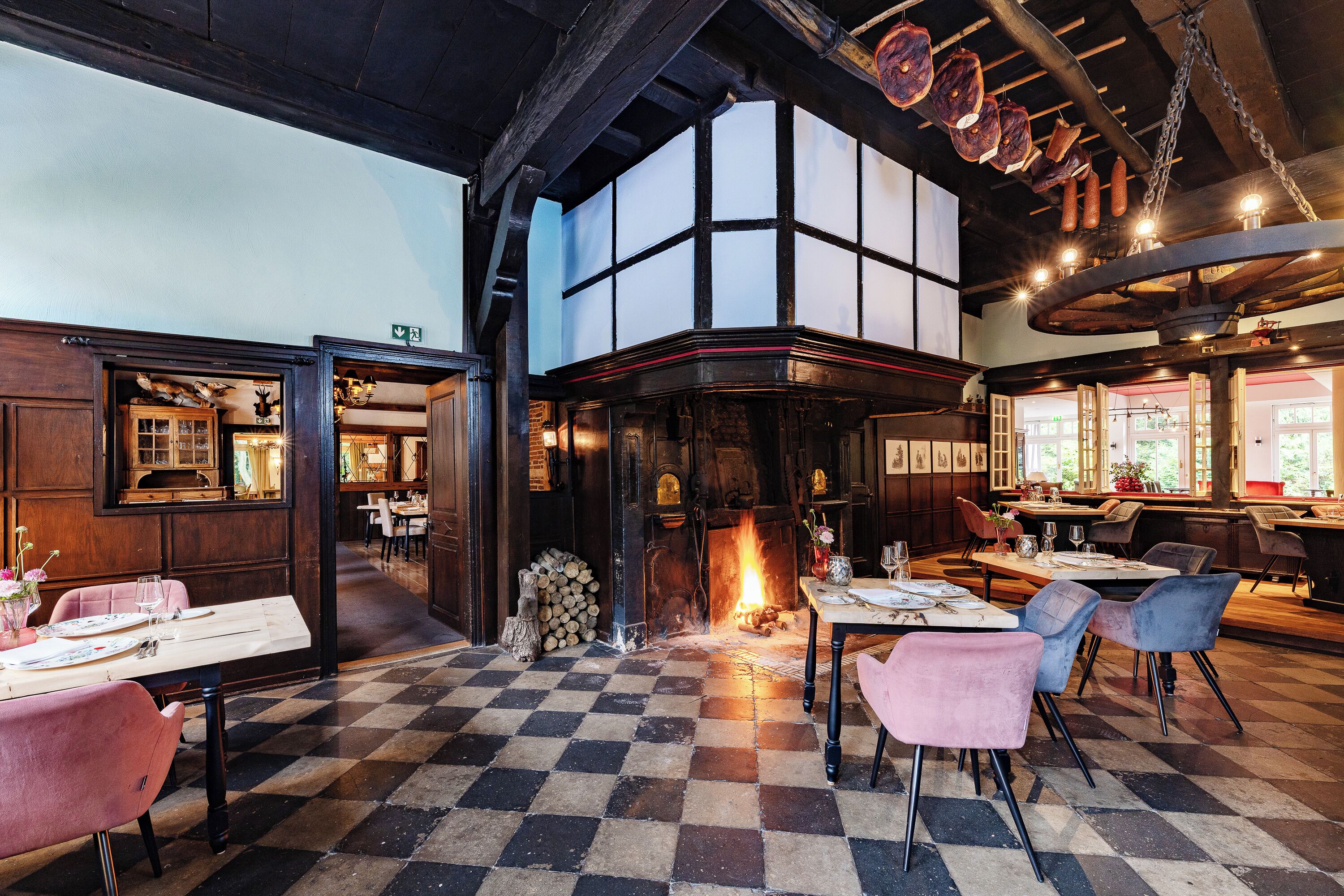 Ein Restaurant mit Schachbrettboden, Holzmöbeln und einem Kamin.