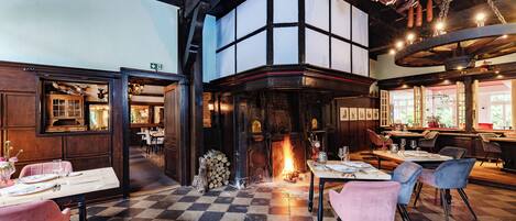 Ein Restaurant mit Schachbrettboden, Holzmöbeln und einem Kamin.