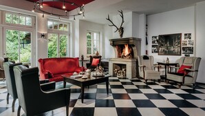 Una sala de estar con chimenea, piso a cuadros y muebles modernos.