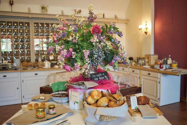 Una mesa de buffet con diversos alimentos y un centro de mesa floral.