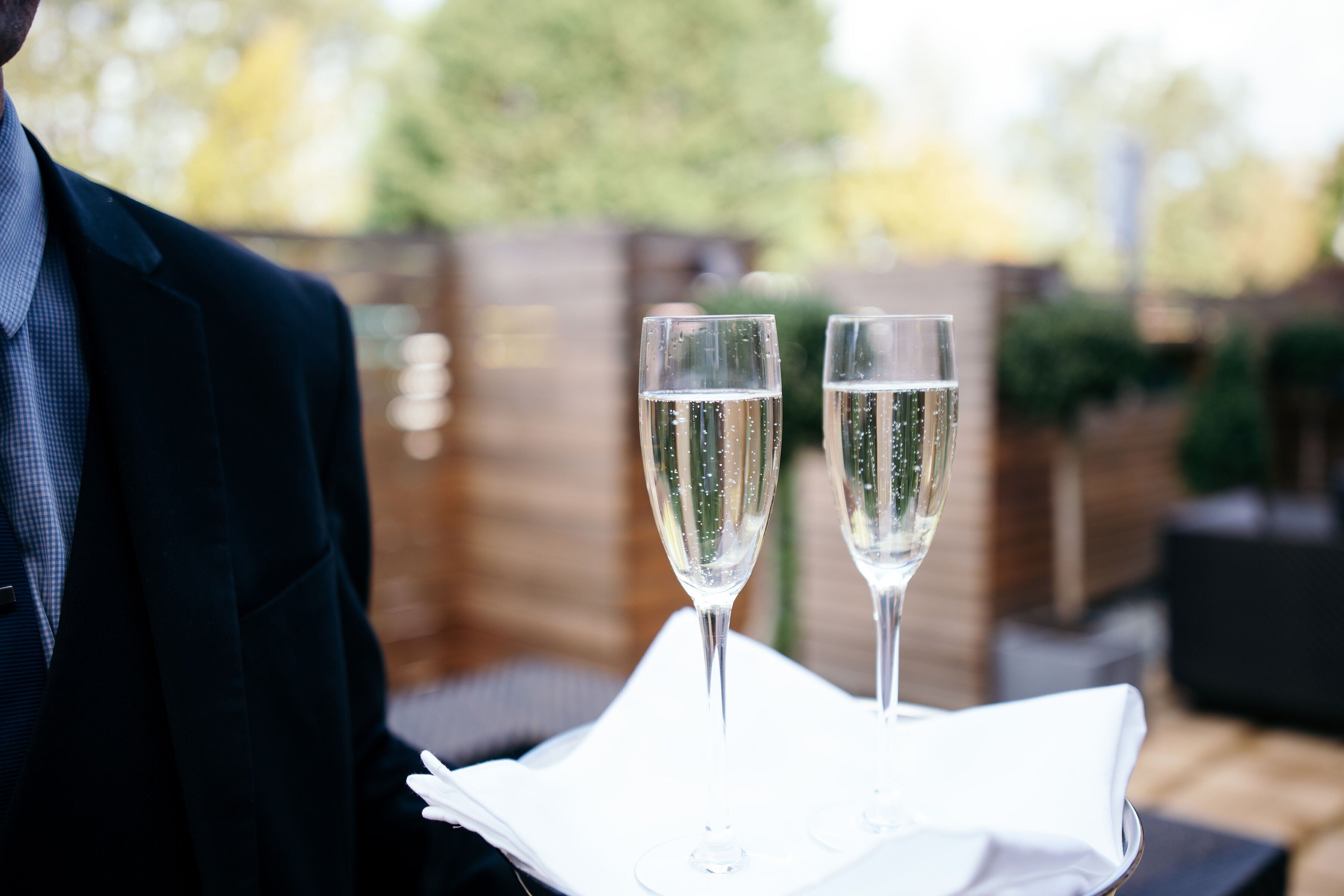 Deux flûtes à champagne posées sur une serviette blanche, sur une table.