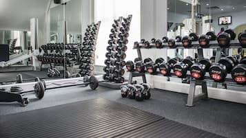 A gym with various weightlifting equipment, including dumbbells and barbells.