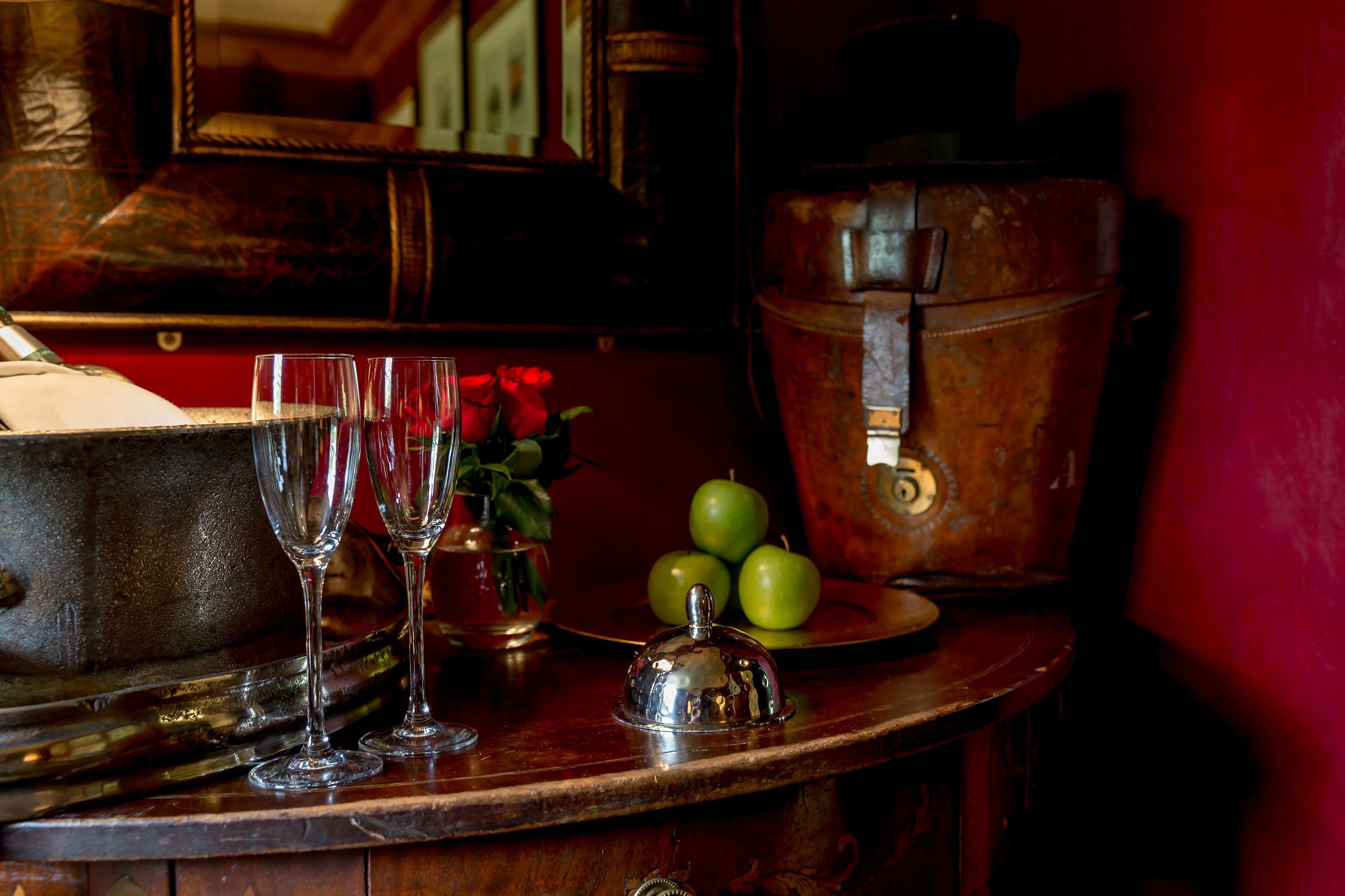 A bar area with a wooden counter, a vintage cash register, and a plate of green apples.