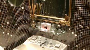 A bathroom with a white sink, a mirror, and a decorative mirror frame.