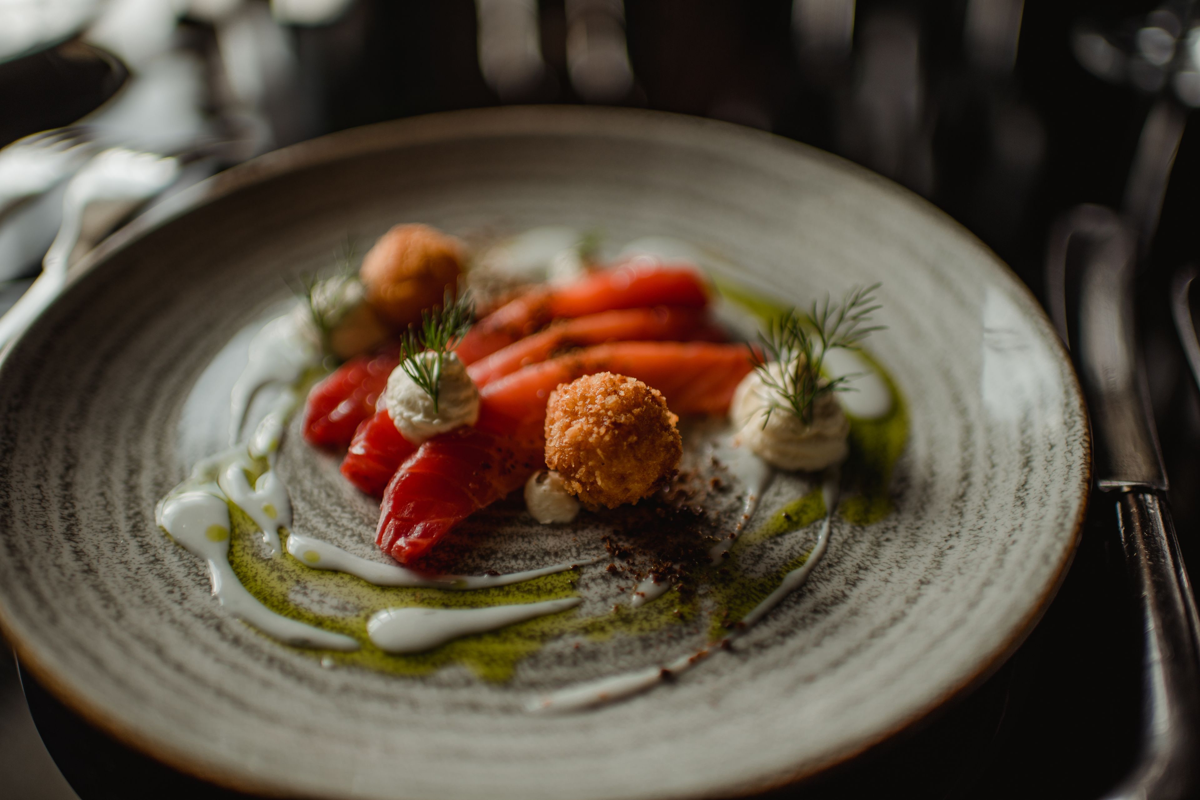 A plate with a variety of food items including carrots, a breaded item, and some greens, possibly served as a dish.