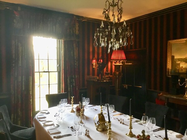 A dining room with a table set for a meal, featuring a chandelier, candles, and a painting on the wall. - Prestonfield House (Edinburgh)