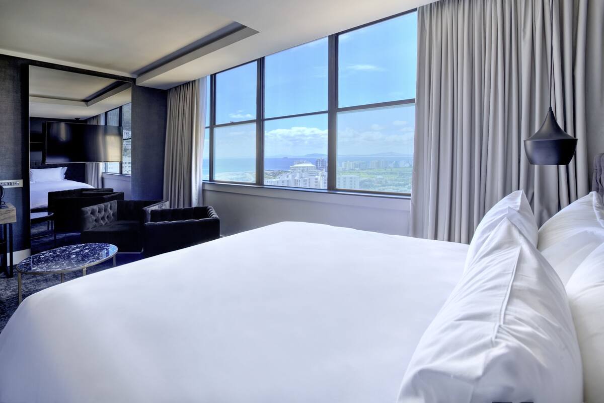 Habitació d'hotel amb un llit gran, una taula, una cadira i una televisió.