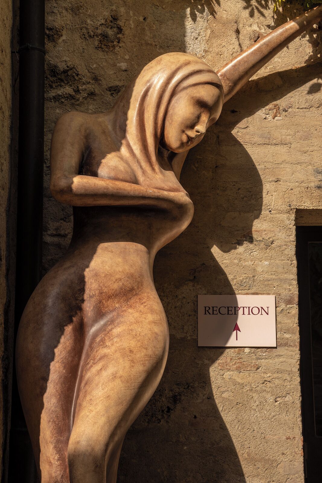 Escultura de una mujer recostada, con un letrero que indica 'RECEPTION' cerca.