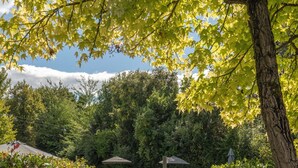 A wooden pathway leading to a pool area with a gazebo and potted plants. - Relais Della Rovere (Colle di Val d'Elsa)
