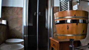 Ein Badezimmer mit Toilette, einer Duschkabine aus Glas und einem Waschbecken aus Holz.