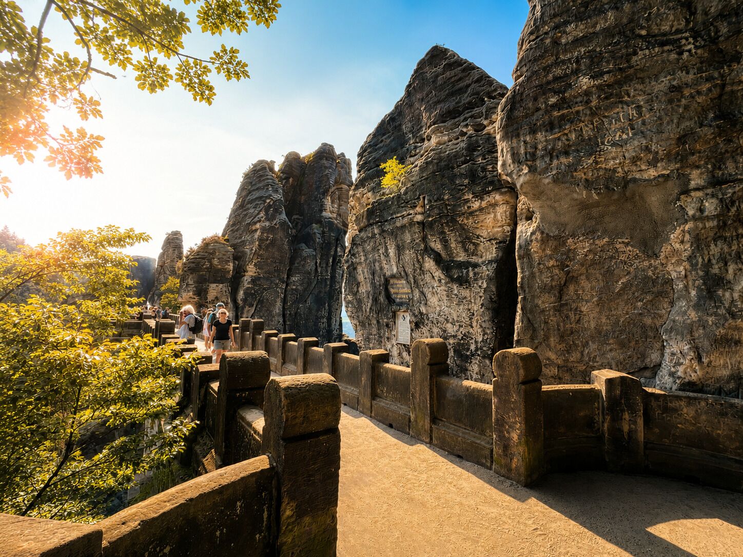 A pathway leading to rock formations with a sign indicating a viewpoint.