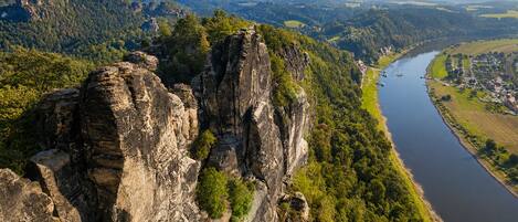 A river with a rocky cliff and a town in the background.