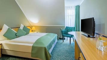 A hotel room with a bed, a desk, a television, and a chair.
