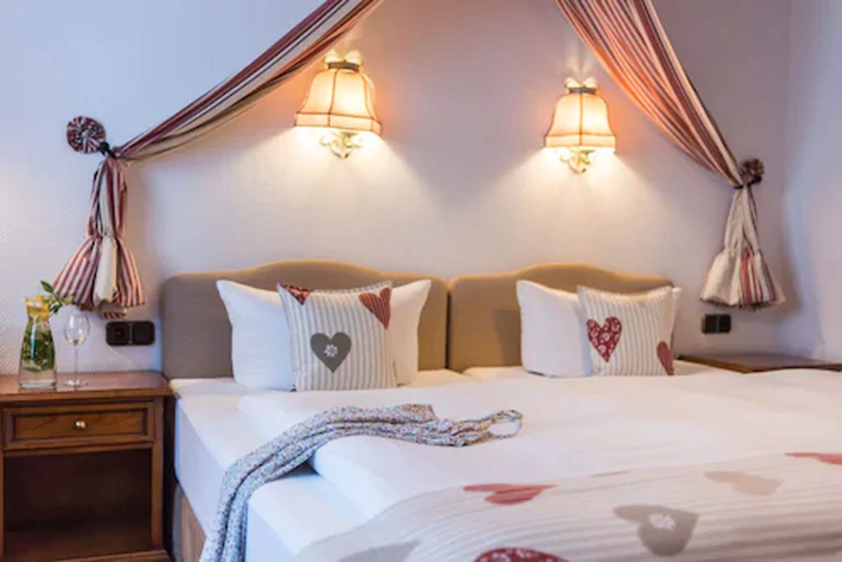 A hotel room with a bed, bedside lamps, and a nightstand.
