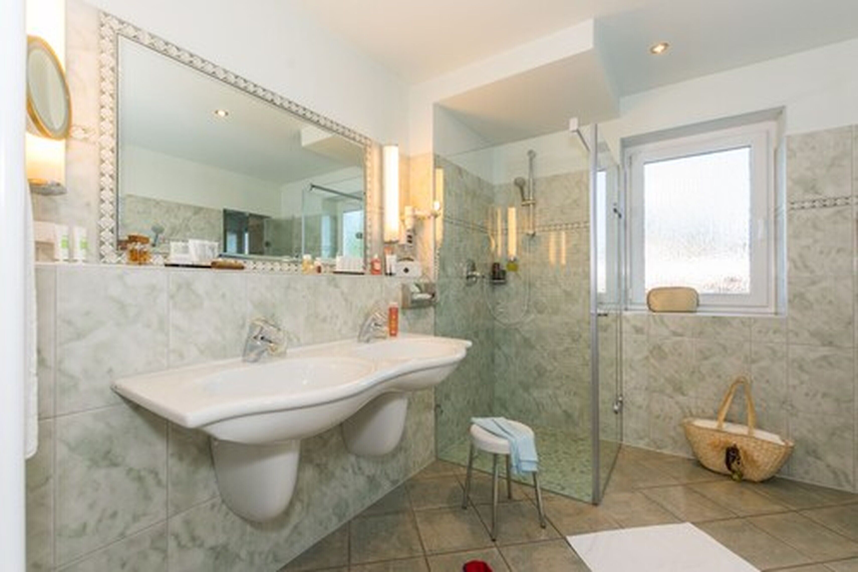 Une salle de bain avec un grand lavabo, un miroir et une douche.