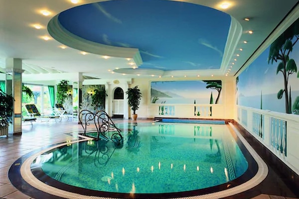 Una piscina techada, sillones reclinables de piscina