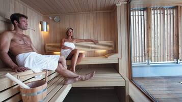 Un sauna avec des bancs en bois et un seau en bois contenant une serviette.