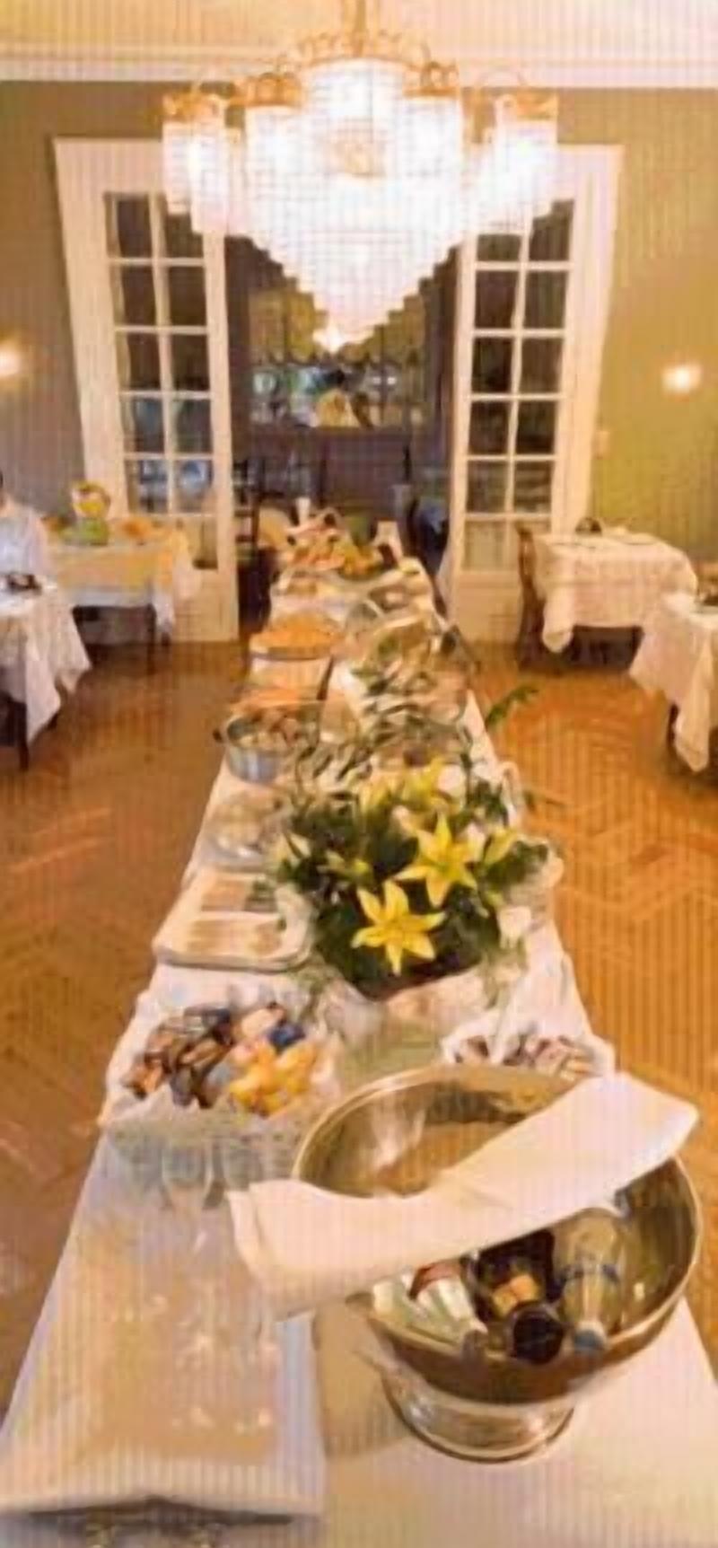 Una larga mesa de buffet con diversos alimentos y un centro de flores amarillas.