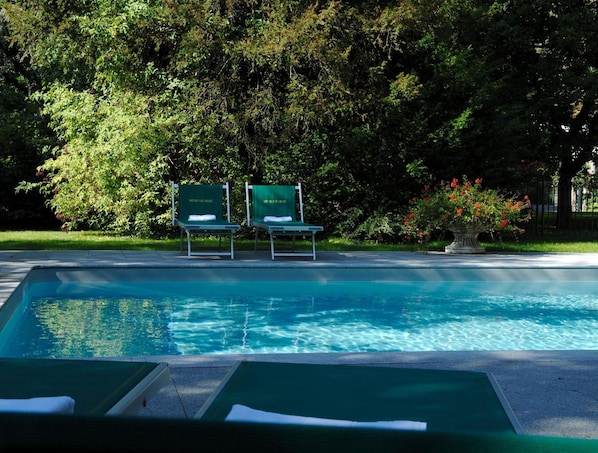 Una piscina al aire libre, tumbonas