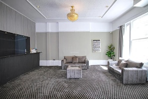 Un salón moderno con un sofá gris, una mesa de centro y una alfombra estampada.