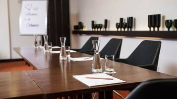 A conference room with a long table, chairs, a whiteboard, and decorative vases.