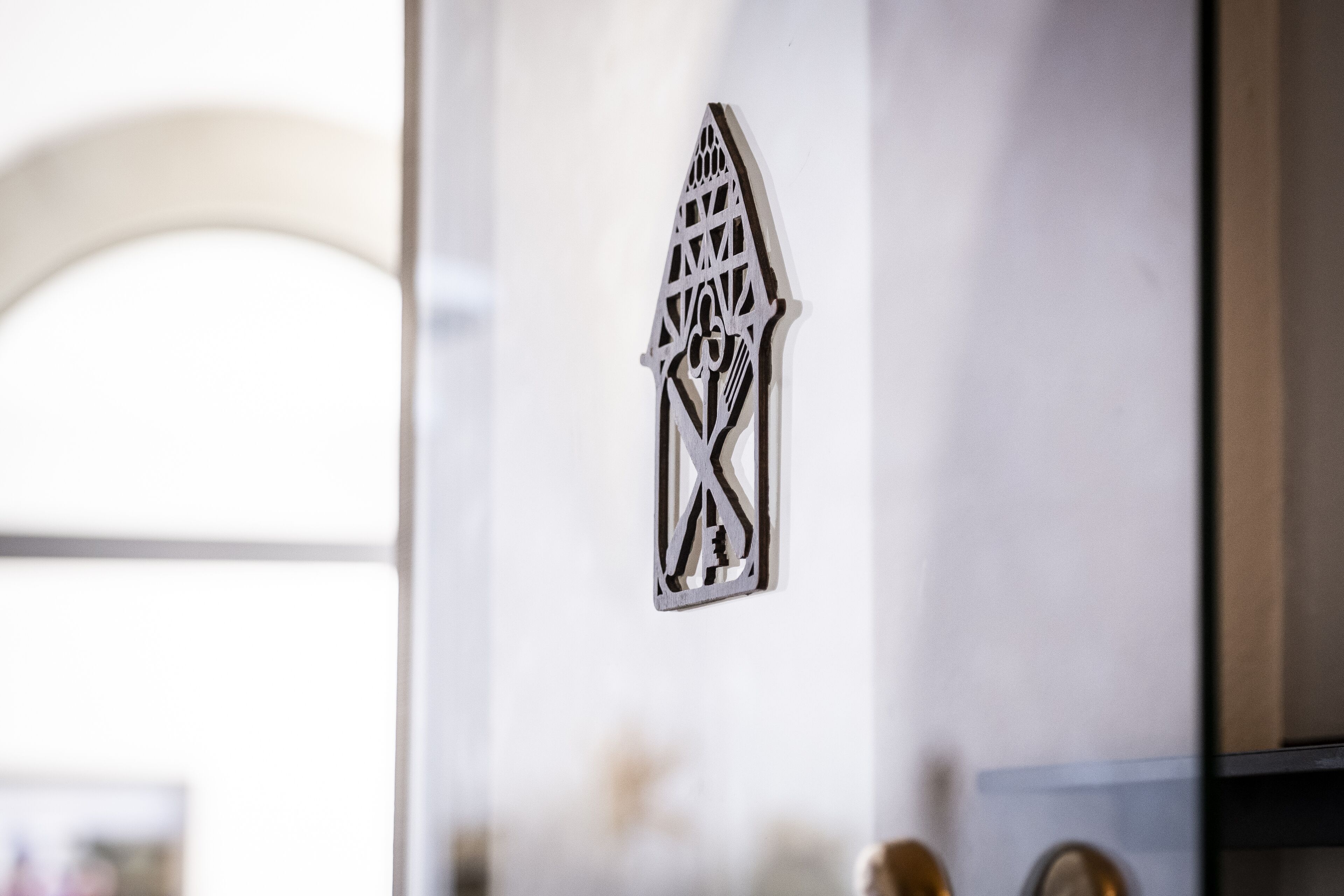 A decorative metal piece with a geometric design on a wall.