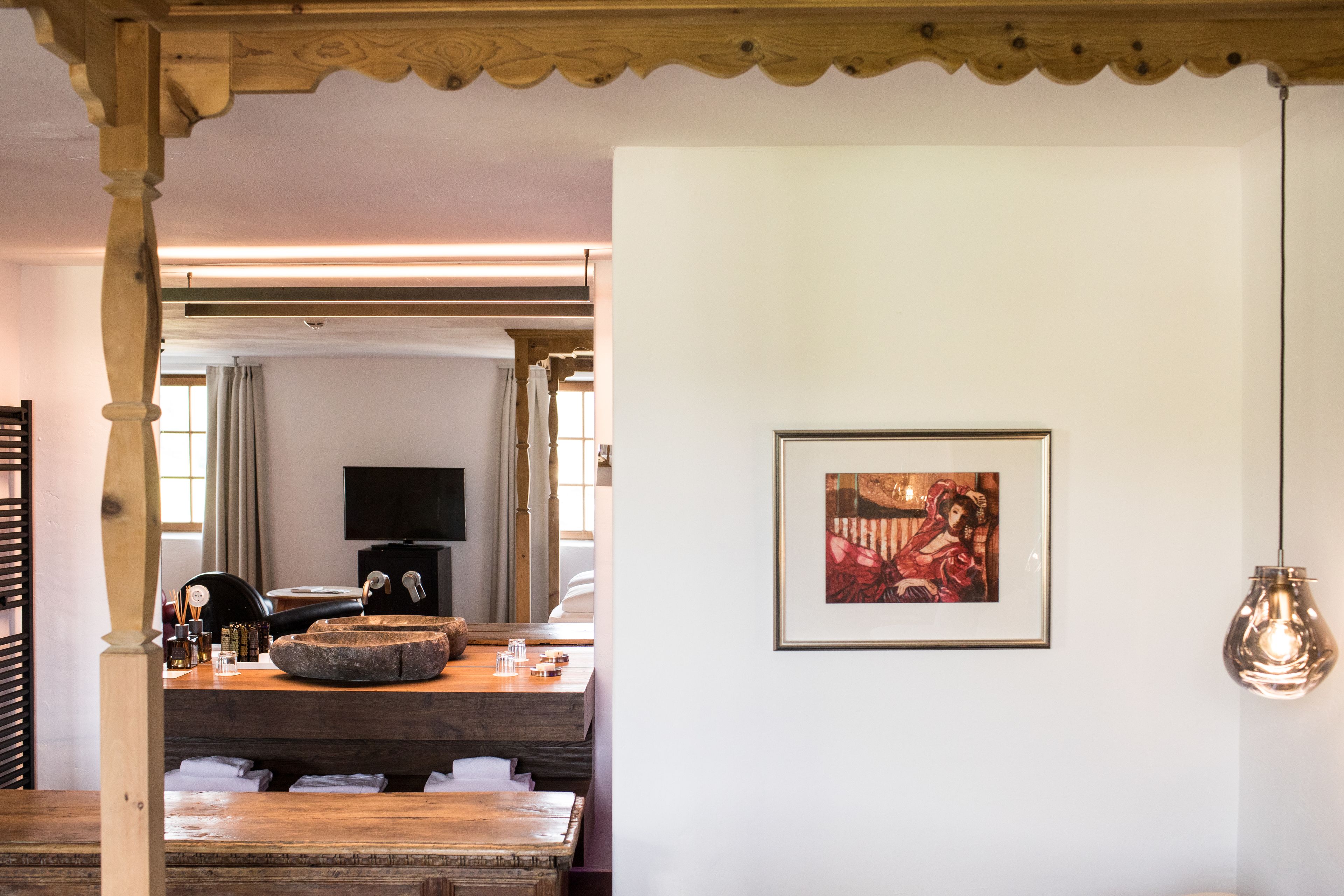 Una habitación con una mesa de madera, un televisor y un cuadro en la pared.
