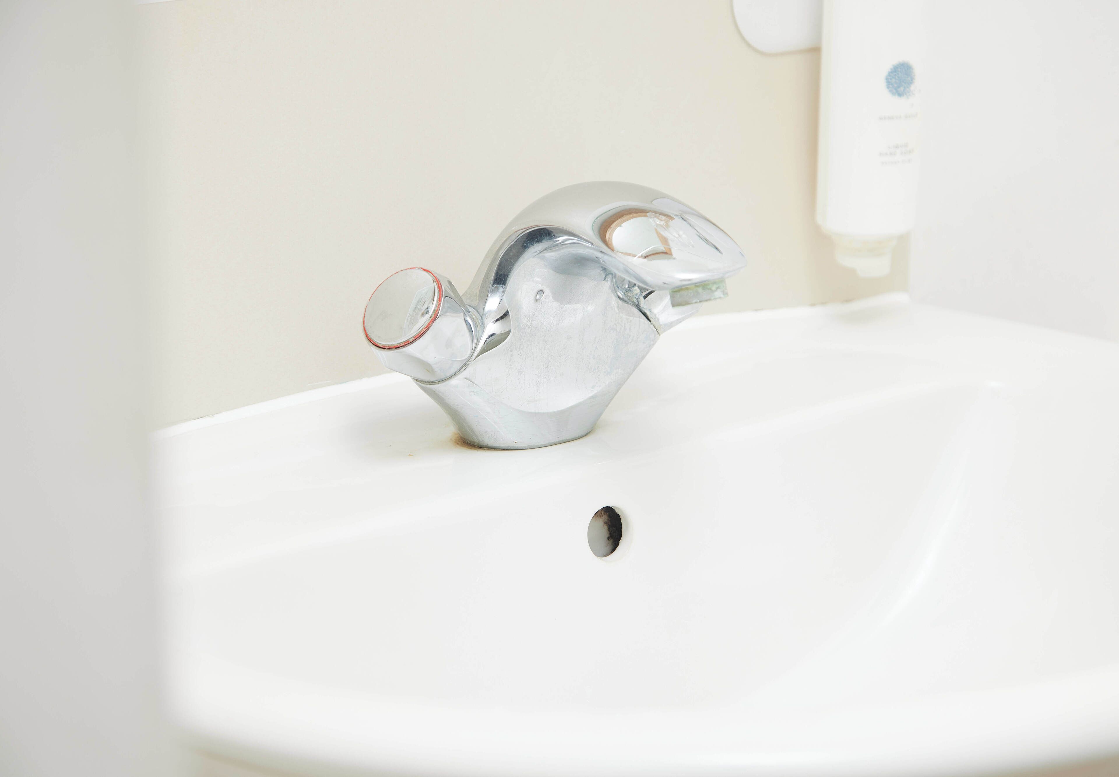 Un lavabo de baño con un grifo moderno y dispensador de jabón.