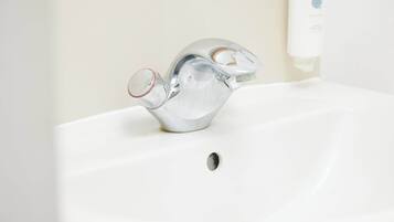 Un lavabo de baño con un grifo moderno y dispensador de jabón.