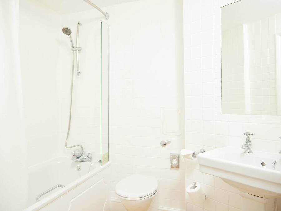 A bathroom with a shower, toilet, and sink.