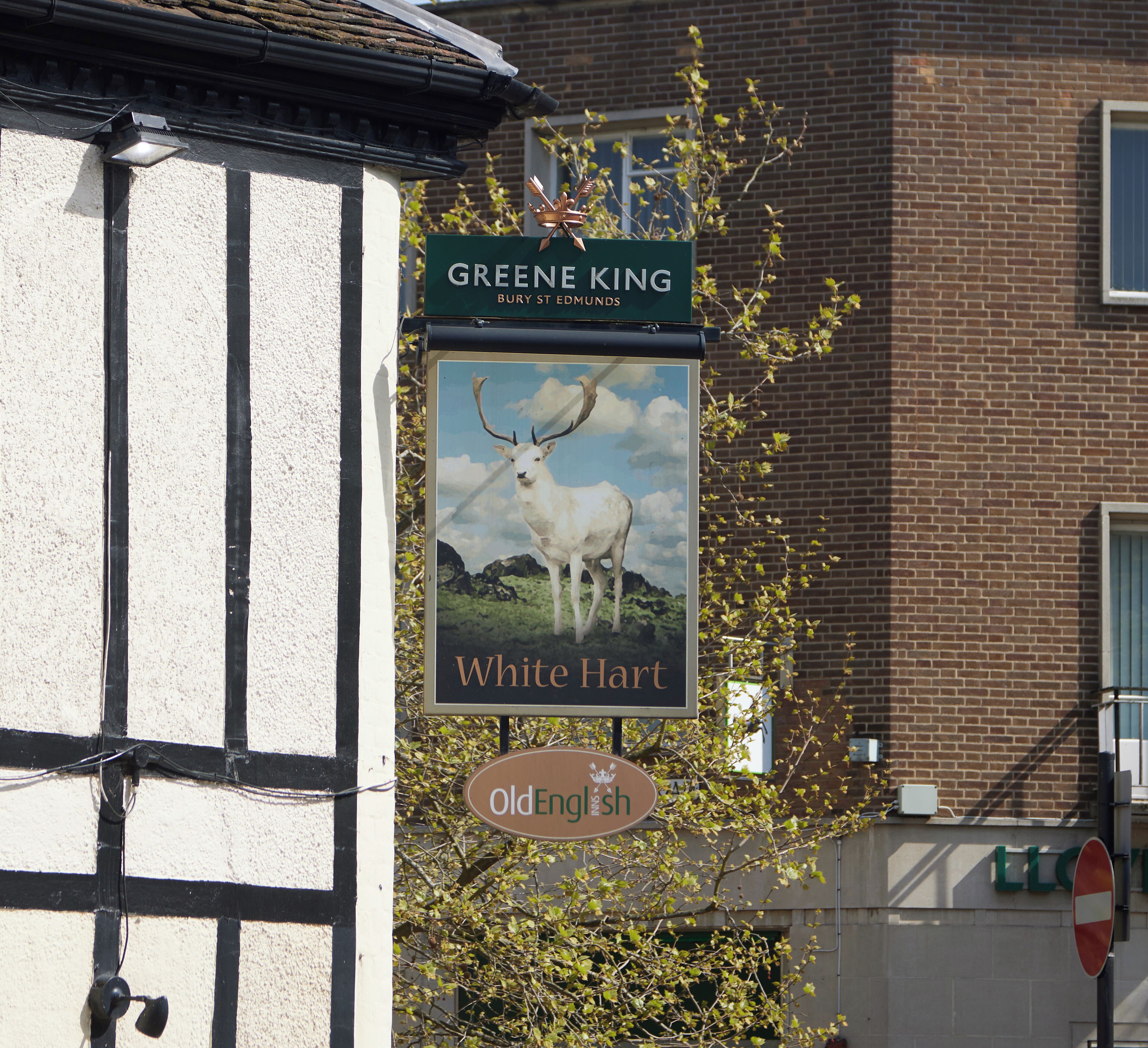 Segno di un pub con un cervo bianco a cuore e la scritta 'White Hart'.